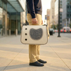 Homme tenant un sac à bandoulière pour chat blanc dans la rue